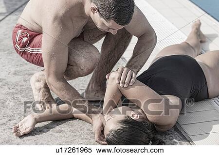 Lifeguard putting woman in recovery position View Large Photo Image Stock Photography - Lifeguard putting woman in recovery position. Fotosearch