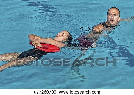Lifeguard rescuing young woman View Large Photo Image Stock Photo - Lifeguard rescuing young woman. Fotosearch