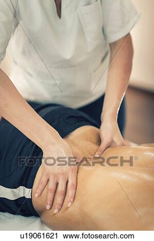 Stock Image - Lower back massage. Fotosearch