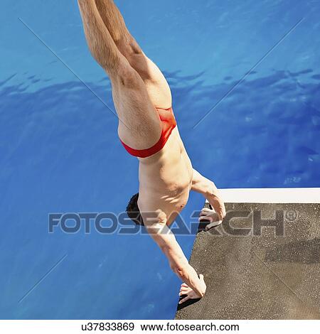 Stock Photo - Male diver in handstand on diving platform. Fotosearch