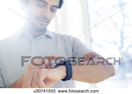 Man checking his smart watch View Large Photo Image Stock Image - Man checking his smart watch. Fotosearch