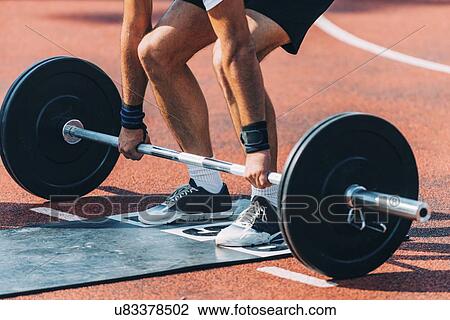 Stock Image - Man lifting barbell. Fotosearch