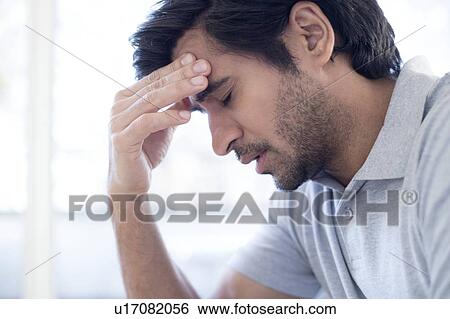 Man touching his forehead in pain View Large Photo Image Stock Photograph - Man touching his forehead in pain. Fotosearch
