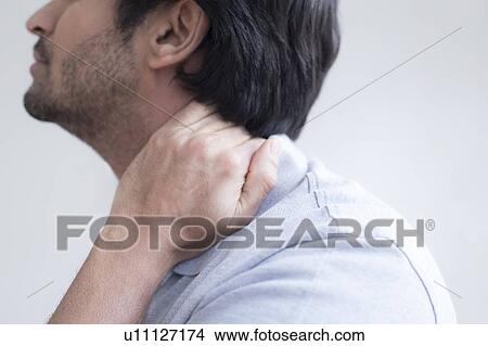 Picture - Man touching his neck in pain. Fotosearch