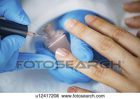 Manicurist painting nails View Large Photo Image Stock Photo - Manicurist painting nails. Fotosearch