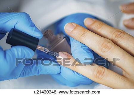 Stock Photograph - Manicurist painting nails. Fotosearch