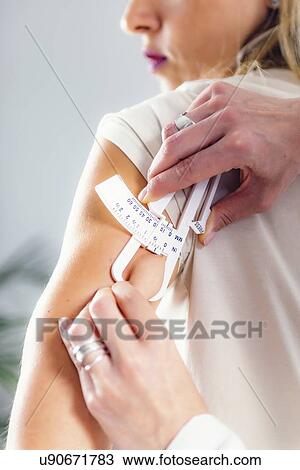 Measuring body fat with callipers View Large Photo Image Stock Image - Measuring body fat with callipers. Fotosearch