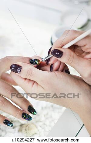 Stock Photo - Nail technician painting nails. Fotosearch