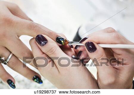 Stock Photo - Nail technician painting nails. Fotosearch