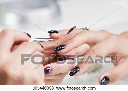 Stock Photo - Nail technician painting nails. Fotosearch