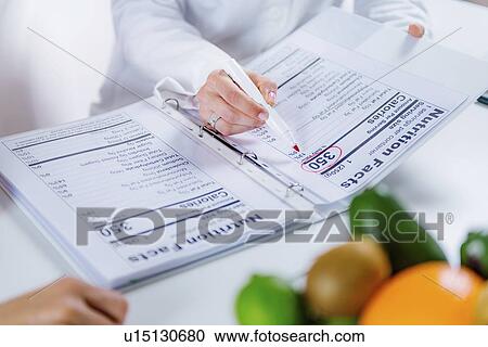 Stock Image - Nutritionist with female patient. Fotosearch