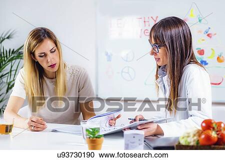 Stock Image - Nutritionist with female patient. Fotosearch