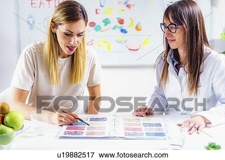 Stock Photo - Nutritionist with female patient. Fotosearch