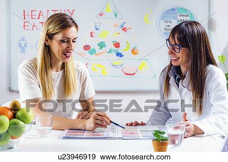 Stock Photo - Nutritionist with female patient. Fotosearch