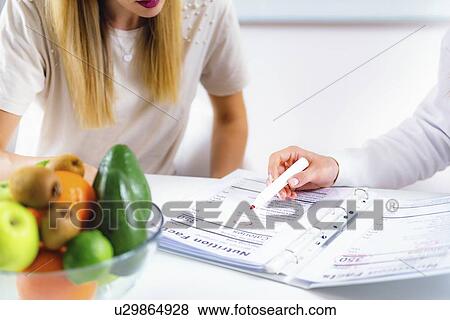 Stock Photo - Nutritionist with female patient. Fotosearch