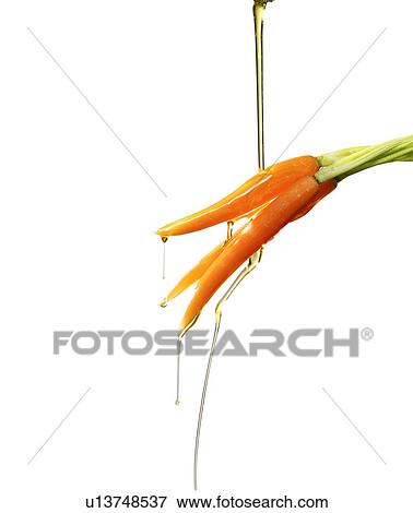 Stock Photo - Oil drizzling on carrots. Fotosearch