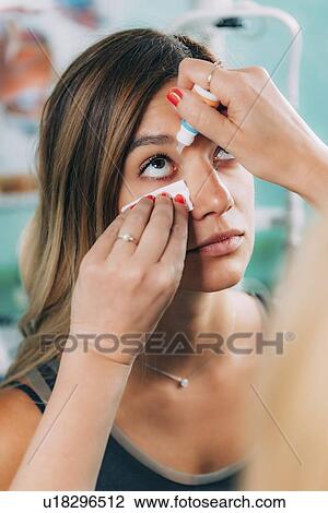 Stock Image - Ophthalmologist applying eye drops. Fotosearch