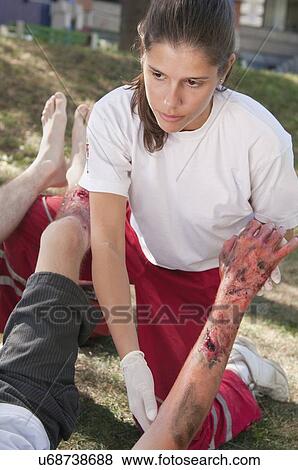 Stock Photo - Paramedic helping a victim with third degree burns. Fotosearch