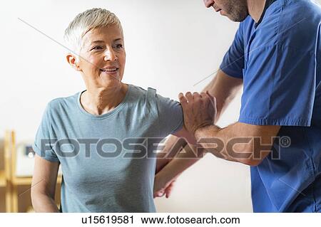 Physical therapist examining patient's arm View Large Photo Image Stock Image - Physical therapist examining patient's arm. Fotosearch