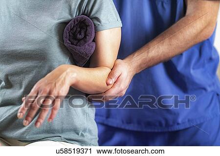 Physical therapist examining patient's arm View Large Photo Image Stock Image - Physical therapist examining patient's arm. Fotosearch