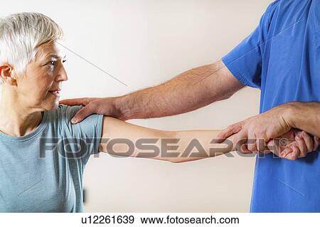 Physical therapist examining patient's elbow View Large Photo Image Stock Photo - Physical therapist examining patient's elbow. Fotosearch