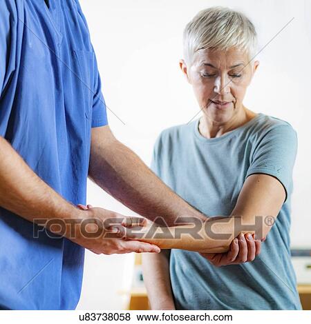Physical therapist examining patient's elbow View Large Photo Image Stock Photo - Physical therapist examining patient's elbow. Fotosearch