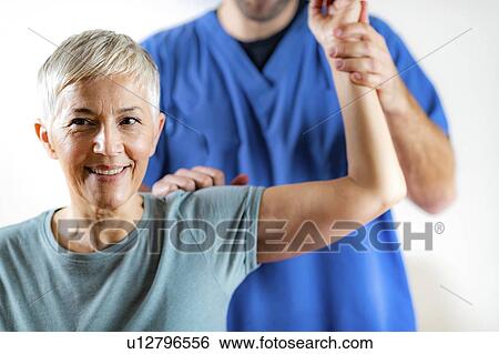 Physical therapist examining patient's arm View Large Photo Image Stock Photograph - Physical therapist examining patient's arm. Fotosearch