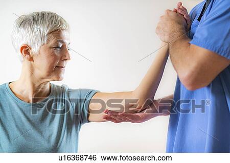 Physical therapist examining patient's elbow View Large Photo Image Stock Photograph - Physical therapist examining patient's elbow. Fotosearch