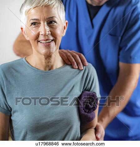 Stock Photograph - Physical therapist examining patient's arm. Fotosearch