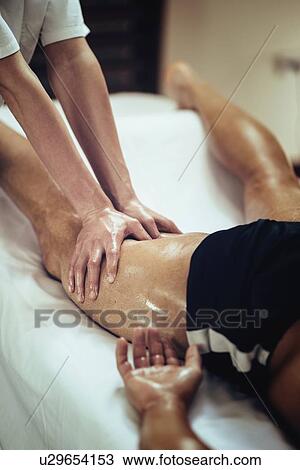 Stock Image - Physical therapist massaging leg. Fotosearch