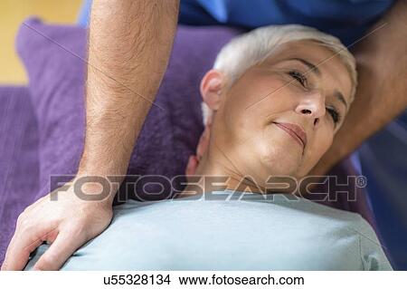 Physical therapist stretching senior woman's neck View Large Photo Image Picture - Physical therapist stretching senior woman's neck. Fotosearch