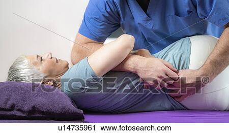 Physical therapist stretching senior woman View Large Photo Image Stock Image - Physical therapist stretching senior woman. Fotosearch