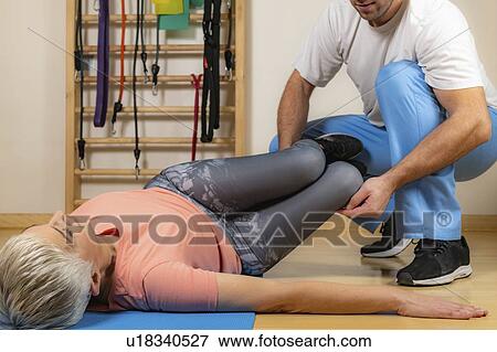 Stock Photo - Physical therapist stretching senior woman. Fotosearch