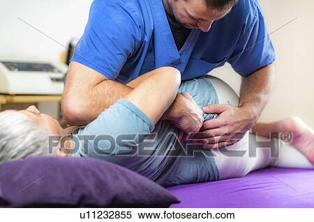 Stock Photography - Physical therapist stretching senior woman. Fotosearch
