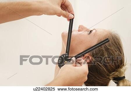 Stock Photography - Physiotherapist measuring neck mobility. Fotosearch