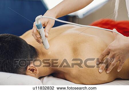 Stock Image - Physiotherapy laser treatment. Fotosearch