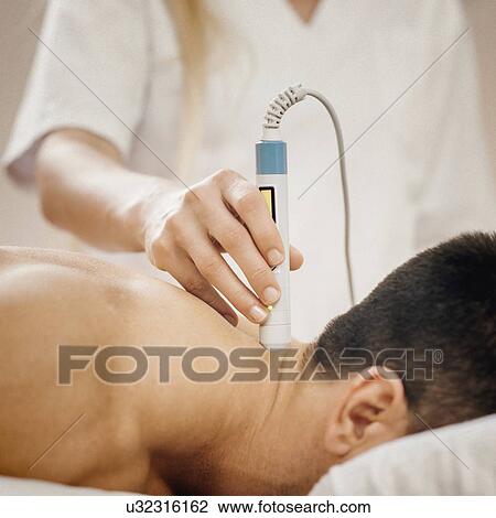 Stock Image - Physiotherapy laser treatment. Fotosearch