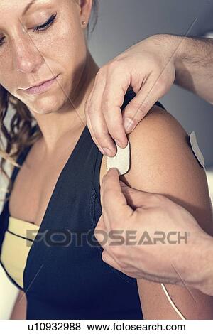 Placing TENS electrodes on shoulder View Large Photo Image Stock Photo - Placing TENS electrodes on shoulder. Fotosearch