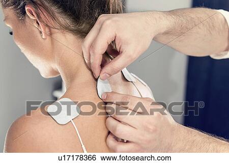Placing TENS electrodes on shoulders View Large Photo Image Stock Photograph - Placing TENS electrodes on shoulders. Fotosearch