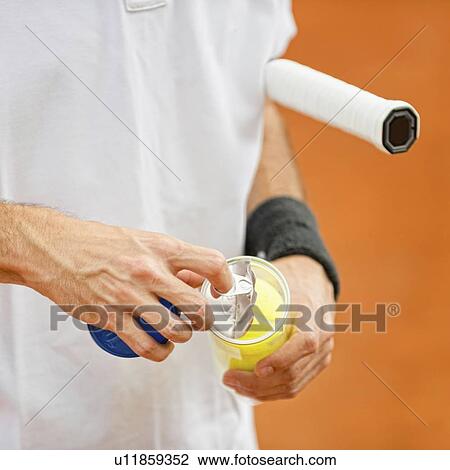 Stock Image - Player opening new tennis balls. Fotosearch