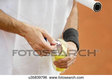 Stock Photograph - Player opening new tennis balls. Fotosearch