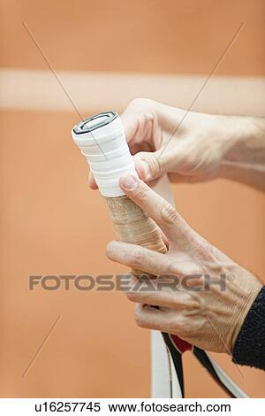 Stock Photography - Player putting new grip tape on tennis racket. Fotosearch