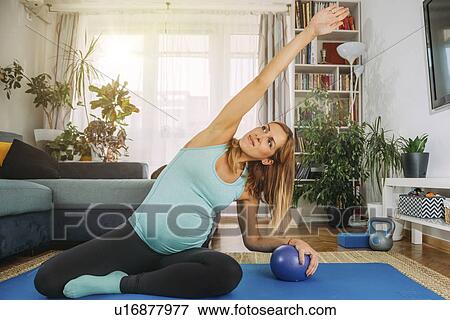 Pregnant woman doing pilates at home View Large Photo Image Stock Photo - Pregnant woman doing pilates at home. Fotosearch