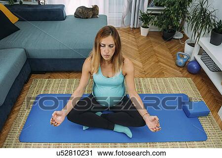 Pregnant woman doing yoga at home View Large Photo Image Stock Image - Pregnant woman doing yoga at home. Fotosearch