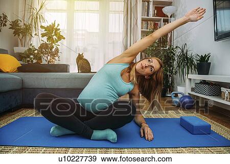 Pregnant woman doing yoga at home View Large Photo Image Stock Photo - Pregnant woman doing yoga at home. Fotosearch