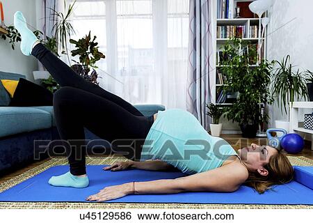Pregnant woman doing yoga at home View Large Photo Image Stock Photograph - Pregnant woman doing yoga at home. Fotosearch