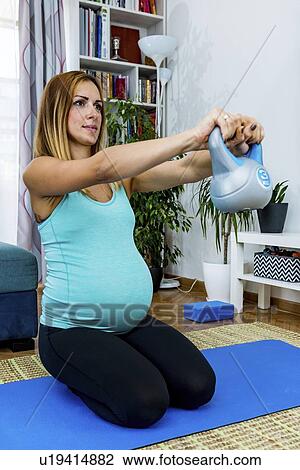 Pregnant woman exercising at home View Large Photo Image Stock Image - Pregnant woman exercising at home. Fotosearch