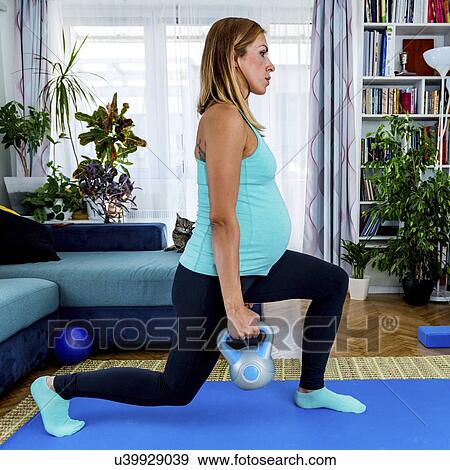 Pregnant woman exercising at home View Large Photo Image Stock Photo - Pregnant woman exercising at home. Fotosearch