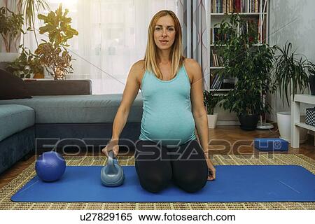 Pregnant woman exercising at home View Large Photo Image Stock Photography - Pregnant woman exercising at home. Fotosearch