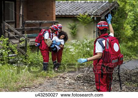 Stock Photo - Rescue team evacuate woman from house. Fotosearch